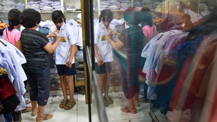 Berburu Perlengkapan Sekolah Jelang Tahun Ajaran Baru Calon pembeli mencoba seragam sekolah yang dijual di Pasar Pringgan, Medan, Sumatera Utara, Jumat (14/7/2023). Menurut pedagang, menjelang tahun ajaran 2023/2024 penjualan seragam sekolah meningkat sekitar 50 persen dari hari biasa dengan harga jual Rp80.000 hingga Rp200.000. ANTARA FOTO/Fransisco Carolio/tom.
