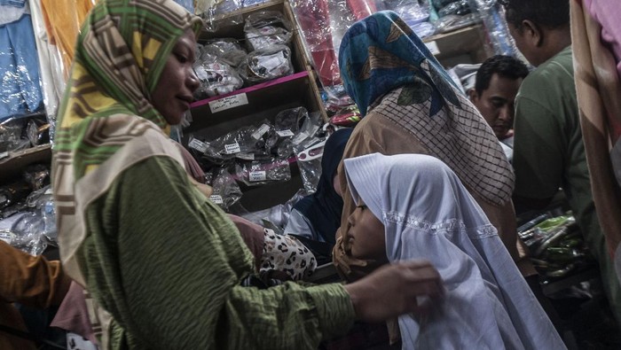 Berburu Perlengkapan Sekolah Jelang Tahun Ajaran Baru Seorang ibu mencoba memakaikan seragam sekolah kepada anaknya saat berbelanja di Pasar Rangkasbitung, Lebak, Banten, Sabtu (15/7/2023). Menurut pedagang setempat, penjualan seragam sekolah pada tahun ajaran 2023/2024 meningkat dari rata-rata 2 setel pakaian pada hari biasanya menjadi 10 setel per hari dengan harga Rp80 ribu hingga Rp250 ribu per setel. ANTARA FOTO/Muhammad Bagus Khoirunas/nym.