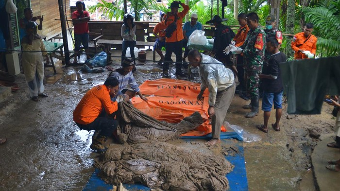 Warga melintas di depan kuburan yang terbongkar akibat longsor di Seberang Padang, Kota Padang, Sumatera Barat, Jumat (14/7/2023). Areal perkuburan di tepi bukit Seberang Padang itu longsor akibat intensitas hujan tinggi sejak Kamis (13/7/23) yang menyebabkan sejumlah makam terbongkar dan belasan jenazah keluar sehingga harus dikuburkan kembali. ANTARA FOTO/Iggoy el Fitra/tom.