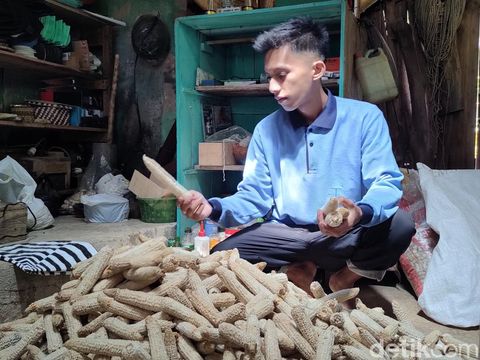 Ade Kurniawan menunjukkan sandal refleksi berbahan tongkol jagung di rumahnya di Dusun Ngaliyan, Kalurahan Ngargosari, Kapanewon Samigaluh, Kulon Progo, Minggu (16/7/2023).