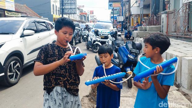 Bocah memainkan pianika saat memburu Om telolet om