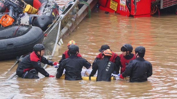 SENSITIVE MATERIAL. THIS IMAGE MAY OFFEND OR DISTURB Rescue workers carry the body of a victim recovered during a search and rescue operation near an underpass that has been submerged by a flooded river caused by torrential rain in Cheongju, South Korea, July 16, 2023.   REUTERS/Kim Hong-ji     TPX IMAGES OF THE DAY