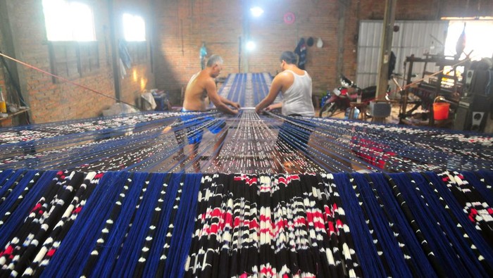 Perajin menyelesaikan pembuatan kain Tenun Ikat Troso di Desa Troso, Pecangaan, Jepara, Jawa Tengah, Sabtu (15/7/2023). Kerajinan tenun yang pembuatannya secara tradisional menggunakan Alat Tenun Bukan Mesin (ATBM) tersebut untuk pembuatan kain pakaian seragam kedinasan dan pakaian adat itu dijual dengan harga Rp60 ribu per lembar yang dipasarkan ke Bali, Sumatera, Kalimantan, dan Sulawesi. ANTARA FOTO/Yusuf Nugroho/nym.