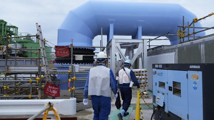 Workers put construction materials away before their lunch break at the Fukushima Daiichi nuclear power plant, operated by Tokyo Electric Power Company Holdings, also known as TEPCO, in Futaba town, northeastern Japan, Friday, July 14, 2023. (AP Photo/Hiro Komae)