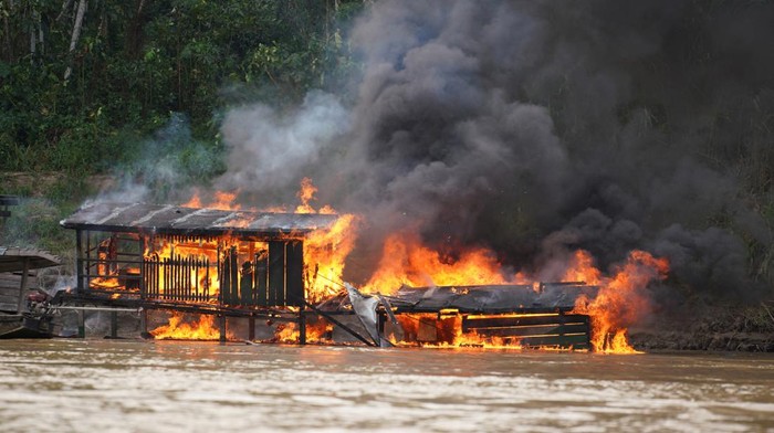 Members of Bolivia's security force stand next to the people detained during an operations against illegal mining, in Madre de Dios River, in Beni Region, Bolivia, in this handout photo released on July 14, 2023. Bolivia's Ministry of Government/Handout via REUTERS ATTENTION EDITORS - THIS IMAGE WAS PROVIDED BY A THIRD PARTY. NO RESALES. NO ARCHIVES