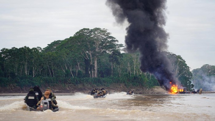 Members of Bolivia's security force stand next to the people detained during an operations against illegal mining, in Madre de Dios River, in Beni Region, Bolivia, in this handout photo released on July 14, 2023. Bolivia's Ministry of Government/Handout via REUTERS ATTENTION EDITORS - THIS IMAGE WAS PROVIDED BY A THIRD PARTY. NO RESALES. NO ARCHIVES