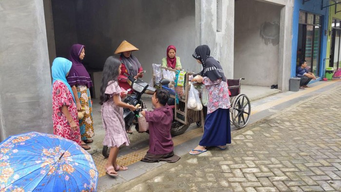 Suara teriakan sayur, sayur disertai bunyi klakson sepeda motor, memecah keheningan pagi di perumahan inklusif di Desa Prambon, Kecamatan Tugu, Trenggalek. Tak berselang lama, sejumlah penghuni mengerumuni pedagang sayur itu.