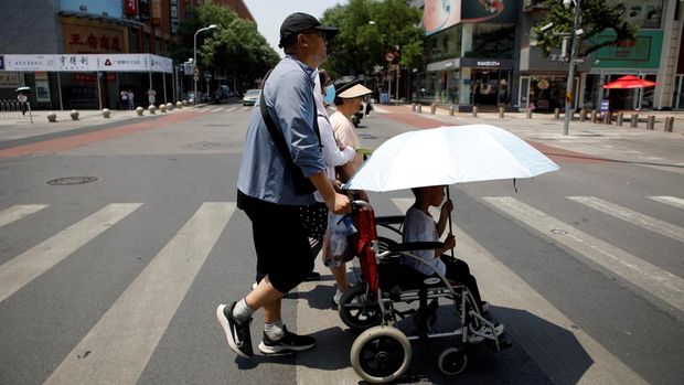 Pejalan kaki menyeberang jalan saat cuaca panas di tengah peringatan oranye untuk gelombang panas, di Beijing, China 16 Juni 2023. REUTERS/Florence Lo/File Foto