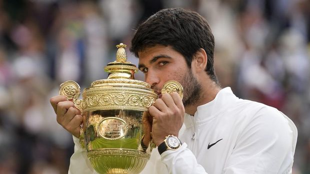 Spain's Carlos Alcaraz celebrates with the trophy after beating Serbia's Novak Djokovic to win the final of the men's singles on day fourteen of the Wimbledon tennis championships in London, Sunday, July 16, 2023. (AP Photo/Kirsty Wigglesworth)