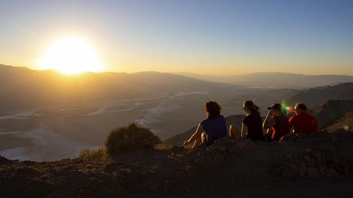Menikmati Lanskap Lembah Kematian Saat Cuaca Lagi Panas-panasnya People run to get sunset photos at Zabriskie Point on Saturday, July 8, 2023, in Death Valley National Park, Calif. July is the hottest month at the park with an average high of 116 degrees (46.5 Celsius). (AP Photo/Ty ONeil)