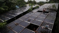 Dua orang anak membersihkan rumput di sekitar panel Pembangkit Listrik Tenaga Surya (PLTS) yang rusak di Kelurahan Foramadiahi, Kota Ternate, Maluku Utara, Sabtu (15/7/2023). Menurut warga setempat, PLTS yang dipergunakan untuk menghidupkan pompa air sudah ada sejak tahun 2015 dan tiga tahun tidak beroperasi karena inverter rusak.