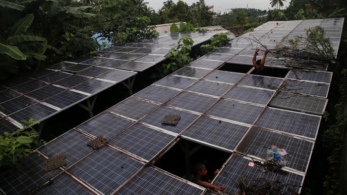 Dua orang anak membersihkan rumput di sekitar panel Pembangkit Listrik Tenaga Surya (PLTS) yang rusak di Kelurahan Foramadiahi, Kota Ternate, Maluku Utara, Sabtu (15/7/2023). Menurut warga setempat,  PLTS  yang dipergunakan untuk menghidupkan pompa air sudah ada sejak tahun 2015 dan tiga tahun tidak beroperasi karena inverter rusak sehingga membutuhkan perawatan dan perbaikan oleh Pemerintah setempat agar kembali normal sehingga warga yang berada di dataran tinggi dapat dialiri air untuk kebutuhan sehari-hari. ANTARA FOTO/Andri Saputra/foc.
