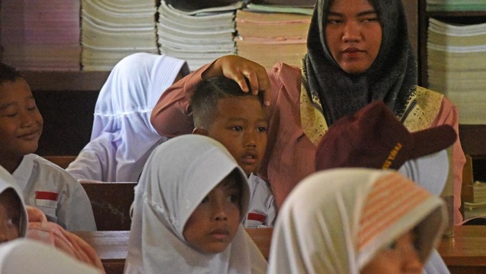 Ibu rumah tangga menenangkan anaknya di dalam kelas saat hari pertama masuk sekolah di SD Negeri Sepang Kota Serang, Banten, Senin (17/7/2023). Hari pertama masuk sekolah tahun ajaran 2023/2024 berlangsung serentak Senin (17/7). ANTARA FOTO/Asep Fathulrahman/foc.