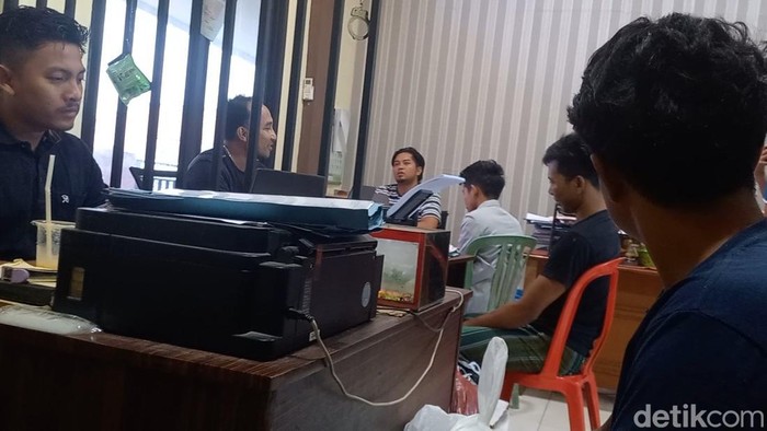 Tiga aktivis yang ditetapkan tersangka pemukulan dokter Puskesmas saat menjalani pemeriksaan di kantor polisi.