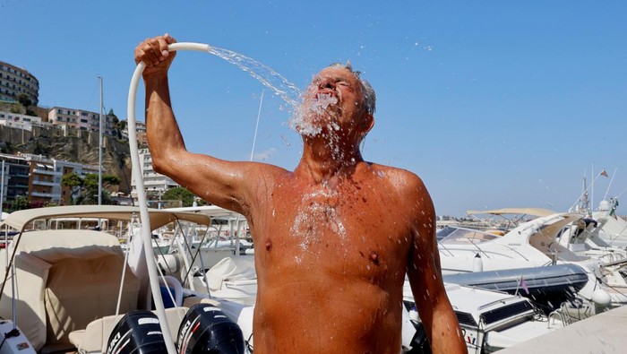 A man cools himself off during a heatwave across Italy, in Naples, Italy July 10, 2023. REUTERS/Ciro De Luca