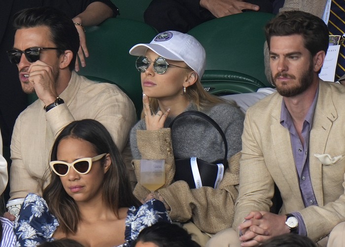 Actor Andrew Garfield, top right, singer Ariana Grande, center, and actor Tom Hiddleston, bottom right, sit in the stands on Centre Court for the final of the mens singles between Spains Carlos Alcaraz and Serbias Novak Djokovic on day fourteen of the Wimbledon tennis championships in London, Sunday, July 16, 2023. (AP Photo/Kirsty Wigglesworth)