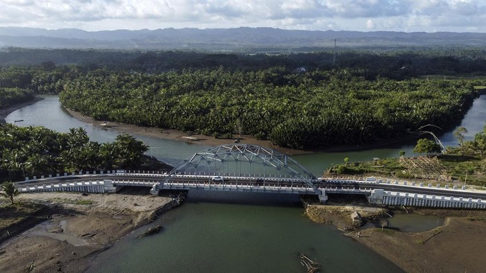 Jembatan Wiradinata Rangga Jipang di Pangandaran Foto udara kendaraan melintasi Jembatan Wiradinata Rangga Jipang di Kabupaten Pangandaran, Jawa Barat, Senin (17/7/2023). Pemerintah Povinsi Jawa Barat telah memperbaiki dan membangun jalan baru atau jalan lintas pantai sepanjang 1.150 kilometer yang menghubungkan Pantai Pangandaran dengan Pantai Madasari, untuk menunjang sektor pariwisata. ANTARA FOTO/Adeng Bustomi/rwa.