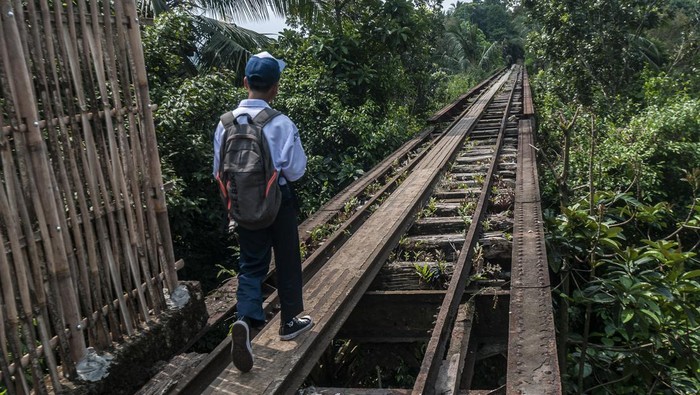 Seorang pelajar berjalan di jalur kereta api Rangkasbitung-Labuan di Saketi, Pandeglang, Banten, Selasa (18/7/2023). PT KAI menargetkan pengerjaan pembangunan fisik untuk reaktivasi jalur kereta Rangkasbitung-Labuan sepanjang 56,6 kilometer pada tahun 2025. ANTARA FOTO/Muhammad Bagus Khoirunas/aww.