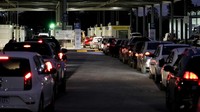 Mobil antre untuk memasuki Argentina dari perbatasan dekat Fray Bentos, Uruguay. Warga Uruguay berbondong-bondong melintasi perbatasan ke Argentina untuk belanja murah karena nilai tukar peso yang anjlok terhadap dolar AS.