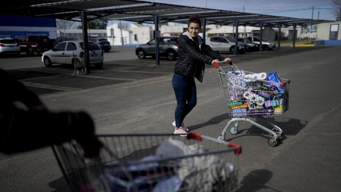 Nilai Peso Merosot, Warga Uruguay Serbu Barang Murah ke Argentina Uruguayan Diana Rocco heads to her car with a full shopping cart outside a super market in Gualeguaychu in the province of Entre Rios, Argentina, Friday, June 30, 2023. From the Uruguayan town of Palmitas, Rocco said she plans to return to Gualeguaychú because her salary as a security guard is barely enough to cover her expenses back home. (AP Photo/Natacha Pisarenko)