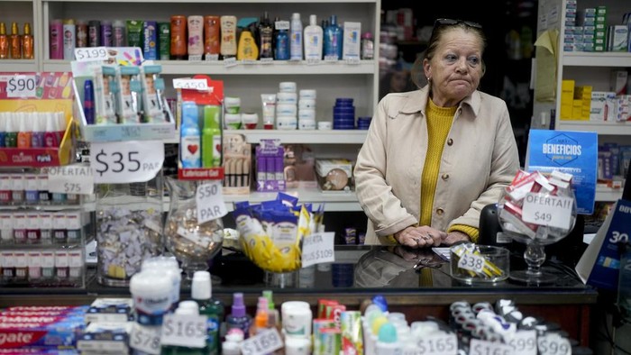Uruguayan Diana Rocco heads to her car with a full shopping cart outside a super market in Gualeguaychu in the province of Entre Rios, Argentina, Friday, June 30, 2023. From the Uruguayan town of Palmitas, Rocco said she plans to return to Gualeguaychú because her salary as a security guard is barely enough to cover her expenses back home. (AP Photo/Natacha Pisarenko)