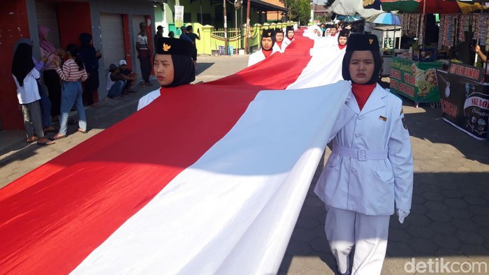 Pawai Taaruf di Pengging, Banyudono, Boyolali menyambut Tahun Baru Islam 1445 Hijriah, Selasa (18/7/2023). Bendera Merah Putih sepanjang 1.000 meter atau 1 km dibentangkan dan diarak dalam pawai ini.