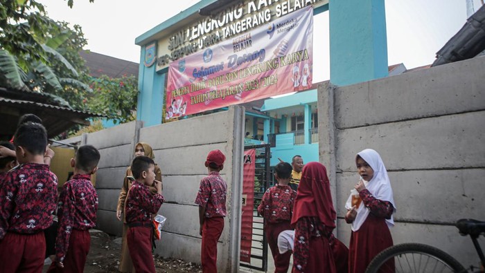 Pelajar berada di depan gerbang sekolah mereka yang ditutup pagar beton di SDN Lengkong Karya, Serpong Utara, Tangerang Selatan, Banten, Selasa (18/7/2023). Akses keluar masuk sekolah tersebut sebagian ditutup tembok beton oleh pemilik lahan karena diduga pemerintah belum melunasi pembayaran lahan itu. ANTARA FOTO/Fauzan/Spt.