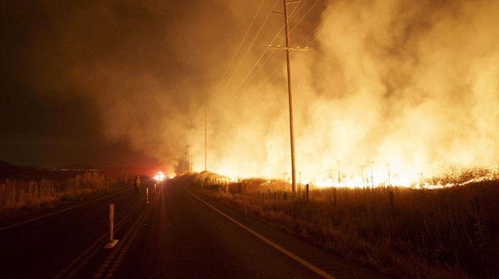 Firefighters monitor as flames consume brush along Gilman Springs Road during the Rabbit Fire late Friday, July 14, 2023, in Moreno Valley, Calif. (AP Photo/Eric Thayer)