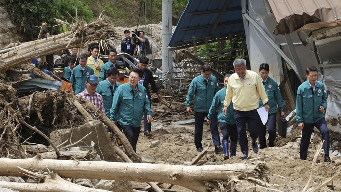 South Korean President Yoon Suk Yeol, bottom center, looks around a flood damaged area in Yecheon, South Korea, Monday, July 17, 2023. (Jin Sung-chul/Yonhap via AP)