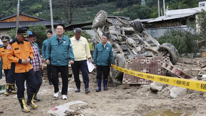 South Korean President Yoon Suk Yeol, bottom center, looks around a flood damaged area in Yecheon, South Korea, Monday, July 17, 2023. (Jin Sung-chul/Yonhap via AP)