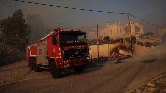 Flames approach a house as a wildfire burns in Saronida, near Athens, Greece, July 17, 2023. REUTERS/Stelios Misinas