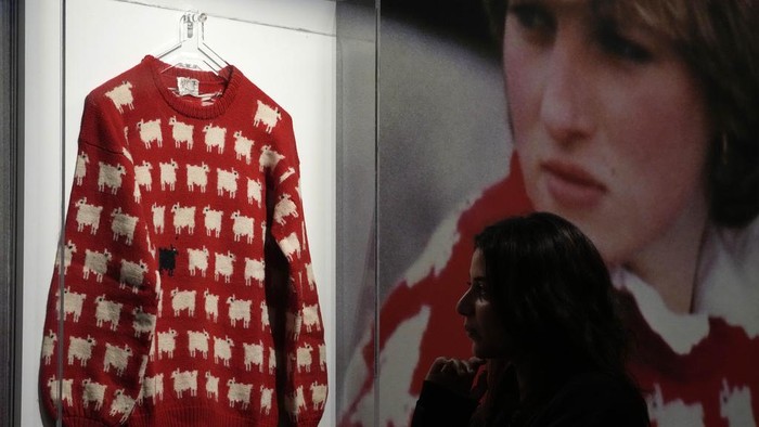 A Sotheby's employee looks at the historic Princess Diana black sheep jumper at the auction house Sotheby's in London, Monday, July 17, 2023. The 'Worn on Several Occasions & Adored by the Fashion Icon' jumper will be on auction headlining Sotheby's inaugural fashion icons sale in New York this September at an Estimate of $50,000 – 80,000, 38,000-61,000 pounds. (AP Photo/Frank Augstein)
