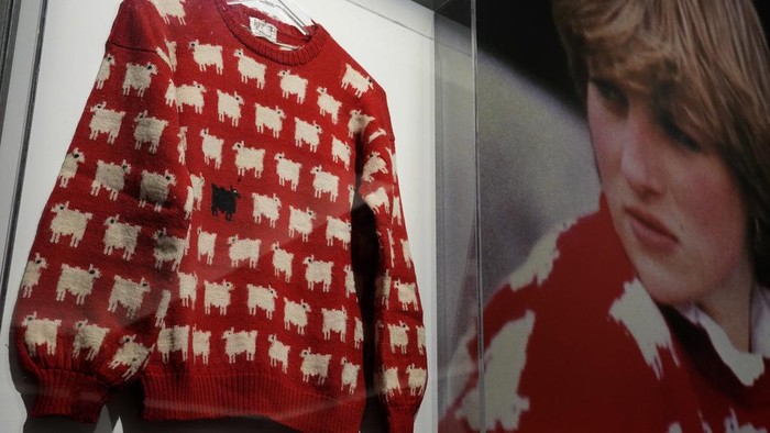 A Sotheby's employee looks at the historic Princess Diana black sheep jumper at the auction house Sotheby's in London, Monday, July 17, 2023. The 'Worn on Several Occasions & Adored by the Fashion Icon' jumper will be on auction headlining Sotheby's inaugural fashion icons sale in New York this September at an Estimate of $50,000 – 80,000, 38,000-61,000 pounds. (AP Photo/Frank Augstein)