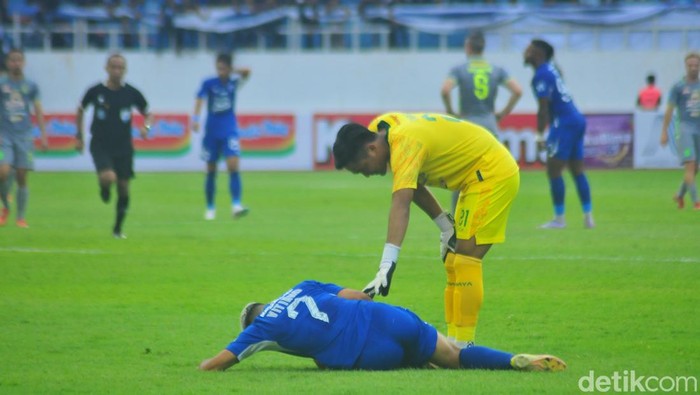 Vitinho (biru) ditarik usai cedera saat laga melawan Persebaya di Stadion Jatidiri Semarang, Minggu (16/72023).