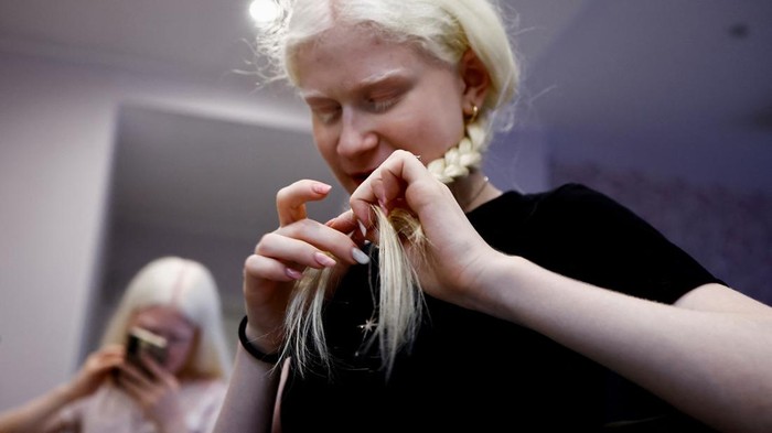 Sisters with albinism and professional models Matilde,17 and Angelica Aureli,15, sit on a bench in a park wearing hats and dark sunglasses, using an umbrella to protect their extra-sensitive skin and eyes from the sun, in Rome, Italy, July 12, 2023. Matilde and Angelica navigate unique obstacles as a heatwave grips Italy. The sisters who try not to go out before sunset, carry a special umbrella and sometimes use a high factor sunscreen to protect their skin from direct sun rays. Albinism is a disease caused by a mutation in genes and typically characterised by pale skin, light hair and poor vision. REUTERS/Yara Nardi