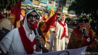 Mereka membawa atribut bendera hingga mikrofon sambil menyanyikan yel-yel.