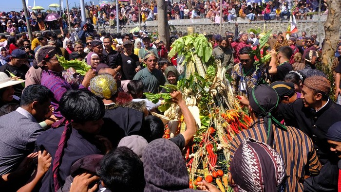 Melihat Tradisi Grebeg Satu Suro di Lereng Gunung Sindoro Warga berebut gunungan palawija saat Grebeg Satu Suro Open Lepen di kawasan lereng Gunung Sindoro Dusun Jumprit, Tegalrejo, Temanggung, Jawa Tengah, Rabu (19/7/2023). Tradisi Open Lepen yang berarti merawat sungai itu rutin dilakukan setiap tahun baru Jawa atau satu Suro yang dilaksanakan dengan kirab keliling dusun, doa bersama, dan grebeg gunungan sebagai permohonn kepada Tuhan agar selama satu tahun ke depan diberi kesuksesan, kelancaran, dan kesejahteraan. ANTARA FOTO/Anis Efizudin/tom.