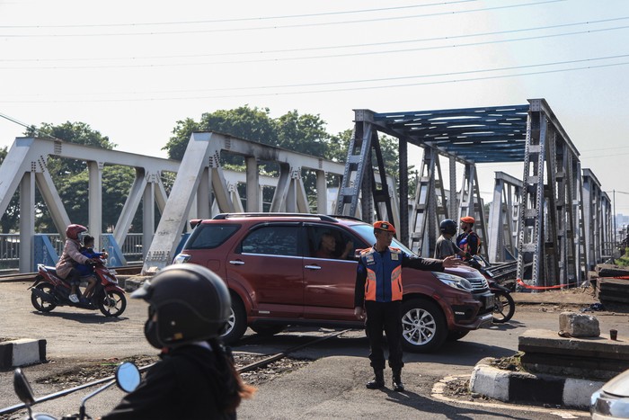 Petugas mengatur lalu lintas di kawasan jalur pascakecelakaan truk tertabrak kereta api (KA) 112 Brantas di perlintasan kereta api petak jalan Jerakah - Semarang Poncol, Madukoro Raya, Semarang, Jawa Tengah, Rabu (19/7/2023). Menurut PT KAI DAOP 4 Semarang, perjalanan KA kembali normal usai sebanyak 10 perjalanan KA jarak jauh tertunda akibat kecelakaan kereta api menabrak truk di jalur itu pada Selasa (18/7) pada pukul 19.28 WIB. ANTARA FOTO/Makna Zaezar/hp.