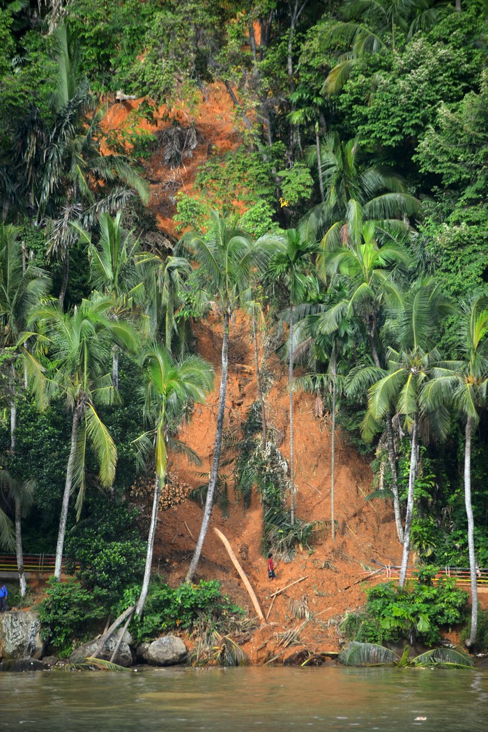 Warga melintas di jalan yang tertimbun longsor di kawasan Gunung Padang, Padang, Sumatera Barat, Kamis (20/7/2023). Jalan wisata ke puncak bukit Gunung Padang yang longsor beberapa hari lalu itu dibuka oleh masyarakat secara manual dan bisa dilewati pejalan kaki namun masih berbahaya karena masih banyak material tanah sekitarnya. ANTARA FOTO/Iggoy el Fitra/nym.