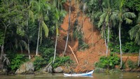 Perahu nelayan melintas di depan jalan yang tertimbun longsor di kawasan Gunung Padang, Padang, Sumatera Barat, Kamis (20/7/2023).   