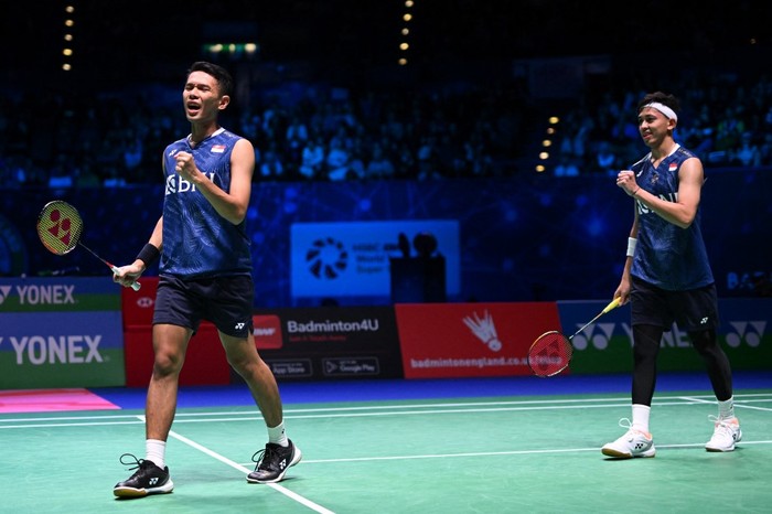 Indonesias Muhammad Rian Ardianto (R) and Indonesias Fajar Alfian (L) celebrate their win over Indonesias Mohammad Ahsan and Indonesias Hendra Setiawan in the Mens Doubles Final at the All England Open Badminton Championships at the Utilita Arena in Birmingham, central England, on March 19, 2023. (Photo by Oli SCARFF / AFP)