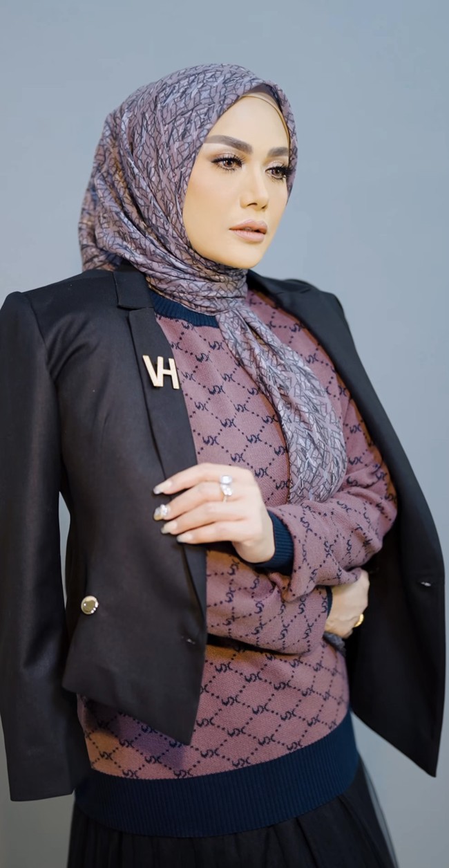 Krisdayanti kini terjun ke politik dan menjadi anggota Dewan Perwakilan Rakyat Republik Indonesia fraksi PDI-Perjuangan periode 2019–2024. Penampilannya terlihat elegan ketika memadukan atasan motif monogram dengan blazer hitam, yang dilengkapi dengan aksesori bros.  Foto: Dok. Instagram @vanillahijab.