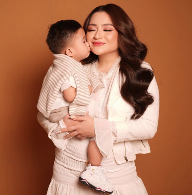 Ini dia foto Nathalie Holscher yang tampil feminin saat pemotretan bersama putra kecilnya. Rambut panjangnya kembali ditata bergelombang. Foto: Instagram @nathalieholscher