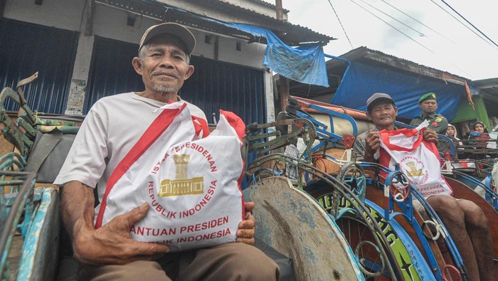 Jokowi Kunjungi Pasar Tradisional di Bengkulu Penarik becak menunjukkan bantuan sembako yang diberikan Presiden Joko Widodo di pasar tradisional Kabupaten Kepahiang, Provinsi Bengkulu, Kamis (20/7/2023). Presiden meninjau kondisi pasar sekaligus menyerahkan Bantuan Langsung Tunai (BLT), Bantuan Usaha UMKM, dan Bantuan Sosial (Bansos) kepada para pedagang dan masyarakat sekitar. ANTARA FOTO/Muhammad Izfaldi/tom.