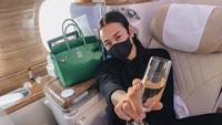 Sebelum penerbangan ke New York, Jovi menunjukkan momen santainya. Ia memegang segelas champagne. Foto: Instagram joviadhiguna