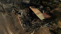 Kebakaran hutan semakin diperparah dengan kondisi cuaca yang panas dan kering. Sebuah rumah terlihat hangus terbakar akibat kebakaran tersebut. REUTERS/Stelios Misinas  