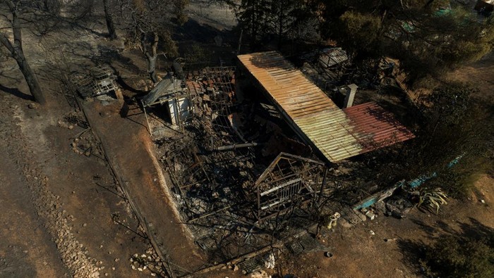 Kebakaran Hutan Yunani Hanguskan Rumah dan Mobil Penduduk A destroyed house is seen following a wildfire in Kouvaras, near Athens, Greece, July 18, 2023. REUTERS/Stelios Misinas