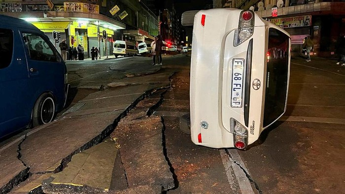Ledakan Misterius Merobek Jalan Utama di Johannesburg People gather on a damaged road after a suspected gas explosion injured people and caused significant damage in the central business district of Johannesburg, South Africa July 19, 2023. REUTERS/Siphiwe Sibeko