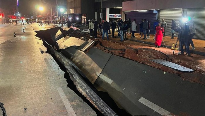 People gather on a damaged road after a suspected gas explosion injured people and caused significant damage in the central business district of Johannesburg, South Africa July 19, 2023. REUTERS/Siphiwe Sibeko