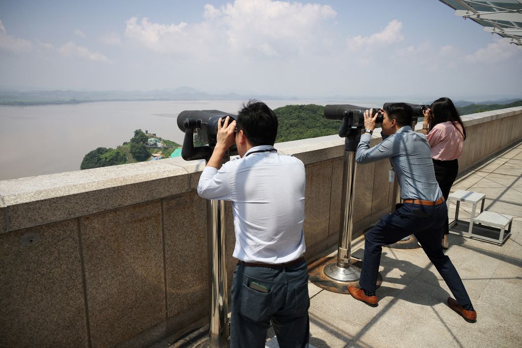 FILE PHOTO: Foreign tourists participating in DMZ tour walk past a military fence near the demilitarized zone separating the two Koreas, in Paju, South Korea July 19, 2023.   (REUTERS/Kim Hong-Ji)